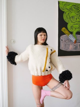 Model mit weißem Pullover in Wohnung