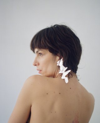Foto von einem Model seitlich angezeigt mit einem weißen Ohrring