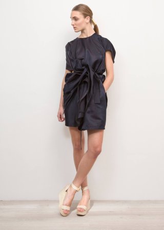 Model trägt ein dunkelblaues Kleid von Femme Maison und dazu hellbeige Sandalen