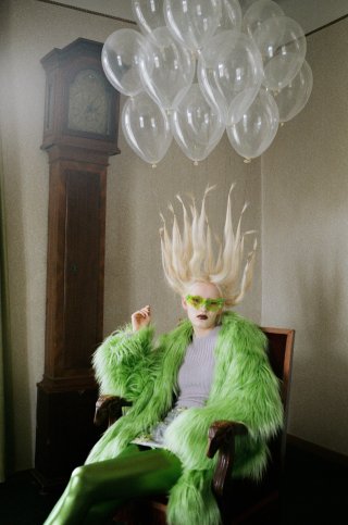 Model in auffälligem Outfit mit Luftballonen