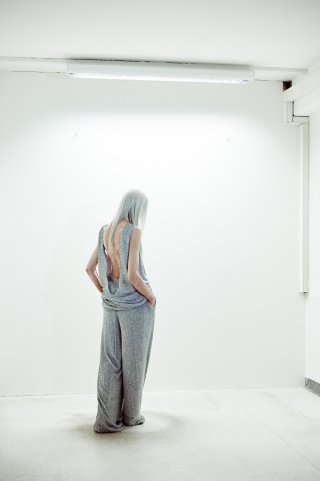 Model in einem grauen Outfit von hinten
