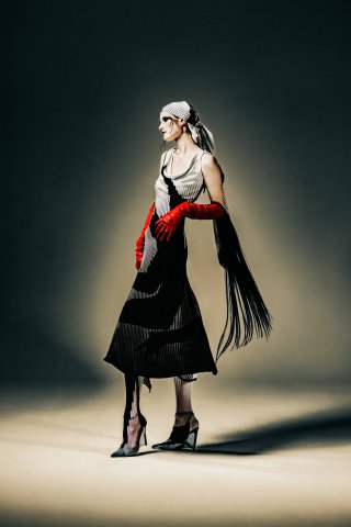Model in schwarz weißem Kleid mit Handschuhen