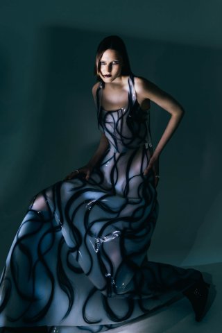 Model in langem Kleid vor dunklem Hintergrund