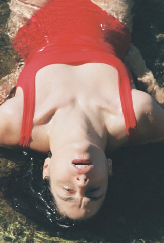 Model in rotem Badeanzug im Wasser