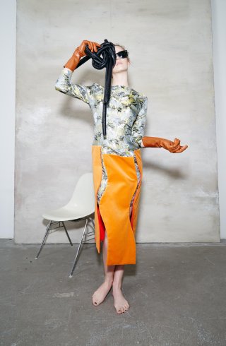 Model mit gemustertem Top und orangenem Rock